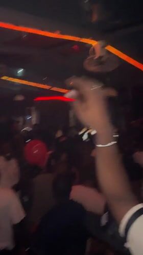 Late-night club scene in Abuja, crowd deep, neons up