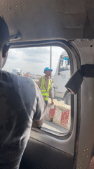 Person leans from vehicle window in Lagos traffic