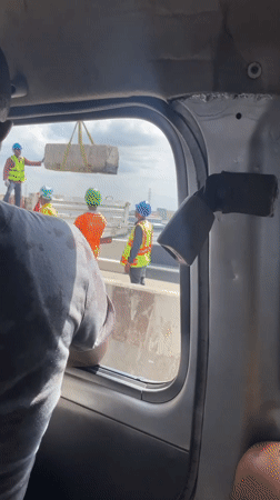 Person leans from vehicle window in Lagos traffic