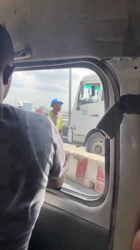 Person leans from vehicle window in Lagos traffic
