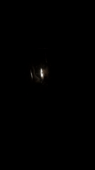 Low-light scenes show flickering candles, bubbling glass in darkness