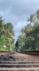 Person walks railway tracks amid Vesak decorations in Ahangama