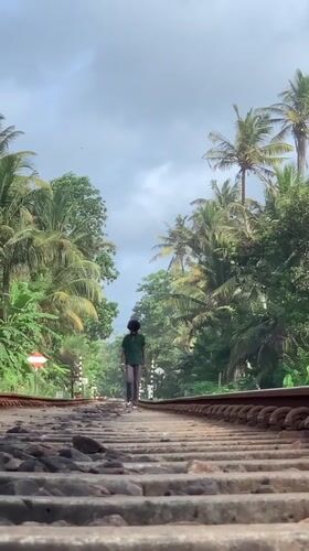 Person walks railway tracks amid Vesak decorations in Ahangama