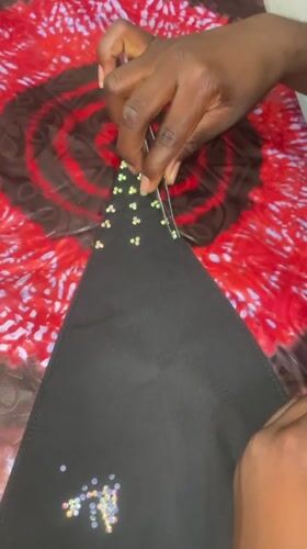 Textile artisan crafts beaded garments in Akwanga workshop