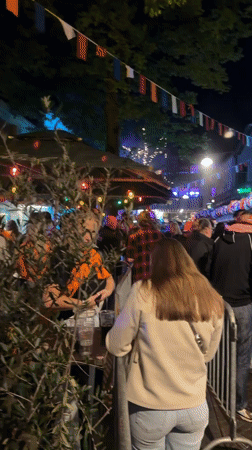 Large crowd gathers on decorated street in Enschede