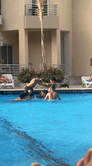 Young men play shoulder-wrestling games in swimming pool