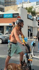Man rides scooter with dog through Tel Aviv streets