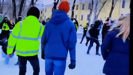 Winter-dressed group gathers in snowy Beryozovka public space