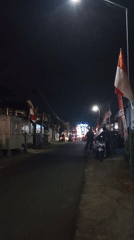 Turen street lit up for a nighttime celebration with flags and stage lights