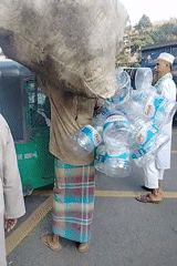 Man carries sack, water bottles through Dhaka streets