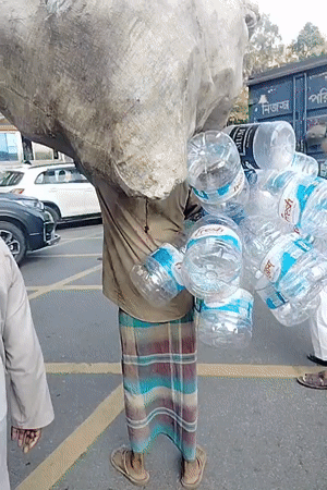 Man carries sack, water bottles through Dhaka streets