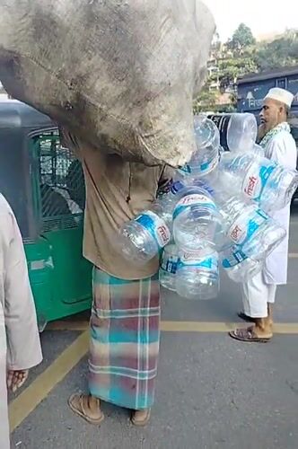 Man carries sack, water bottles through Dhaka streets