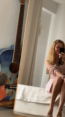 Woman takes mirror selfie on bed in Thailand