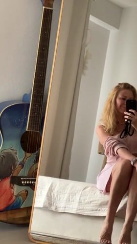 Woman takes mirror selfie on bed in Thailand