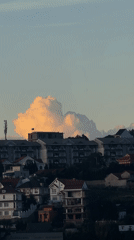 Illuminated cloud formation recorded over Da Lat hillside buildings