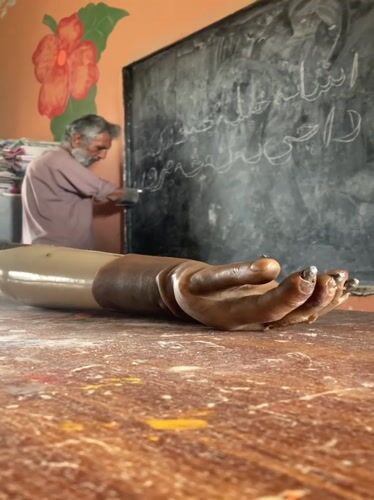 Elderly amputee teacher conducts lesson in Pakistani classroom
