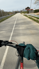 Cyclist rides red bicycle on guarded road near Djulunitsa