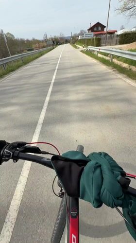 Cyclist rides red bicycle on guarded road near Djulunitsa