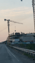 Construction cranes lift materials at Russky building site