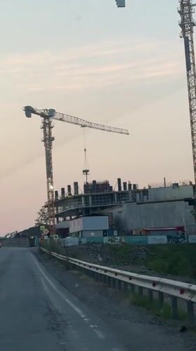 Construction cranes lift materials at Russky building site