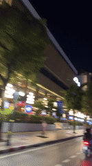 Evening motorcycle traffic flows near Bangkok's Landmark hotel