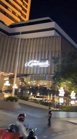 Evening motorcycle traffic flows near Bangkok's Landmark hotel