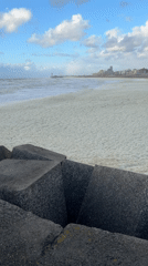 Heavy sea foam blankets The Hague coastline during evening hours