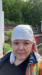 Woman in headscarf observed in rural garden setting