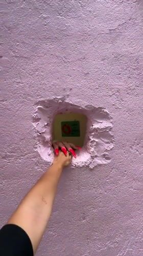 Visitors interact with pink wall art installation in Kuala Lumpur