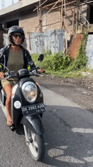 Woman rides Honda scooter in North Kuta, Indonesia