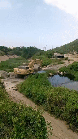 Excavator dredging a shallow waterway in Camurí Grande, Venezuela