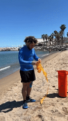 Man prepares paddleboard equipment on Barcelona beach