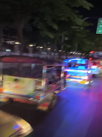 Bangkok nighttime traffic with illuminated tuk-tuks captured by witnesses