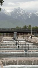 Park waterfall feature observed in Almaty amid mountain backdrop
