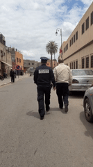 Police officer walks narrow street in Marrakesh