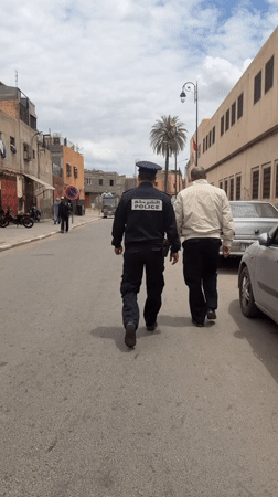 Police officer walks narrow street in Marrakesh