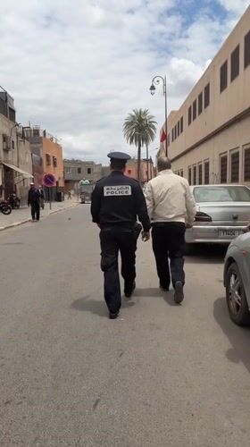 Police officer walks narrow street in Marrakesh