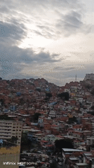 Evening documentation captures Caracas hillside neighborhoods under overcast skies