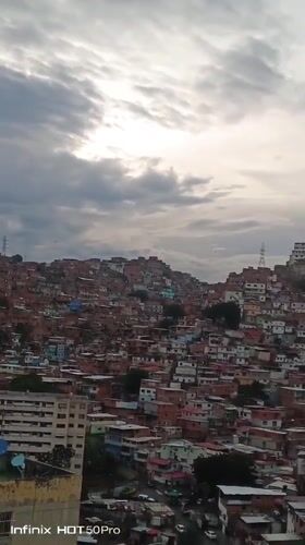 Evening documentation captures Caracas hillside neighborhoods under overcast skies
