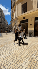 Street acrobats perform on brick-paved road in Málaga