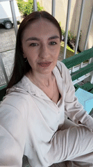 Woman in beige outfit sits on bench in Sochi
