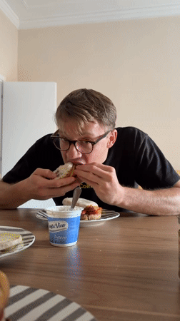 Man enjoys prosciutto sandwich at Catania restaurant