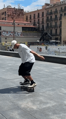 Skateboarders perform tricks in sunny Barcelona plaza