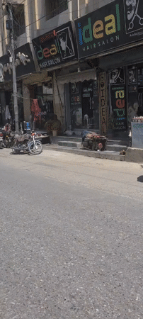 Morning street scene captured in Quetta showing hair salons, motorcycles