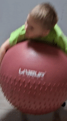 Children play with exercise ball and toy truck indoors