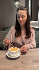 Woman in silver headpiece enjoys coffee, takes selfie in Russia