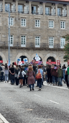 Crowd gathers near historic stone building in Santiago