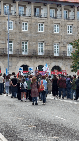 Crowd gathers near historic stone building in Santiago