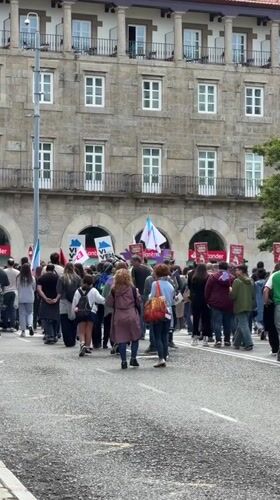 Crowd gathers near historic stone building in Santiago