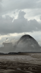 Ship discharges dark material onto sandy shore in Nigeria